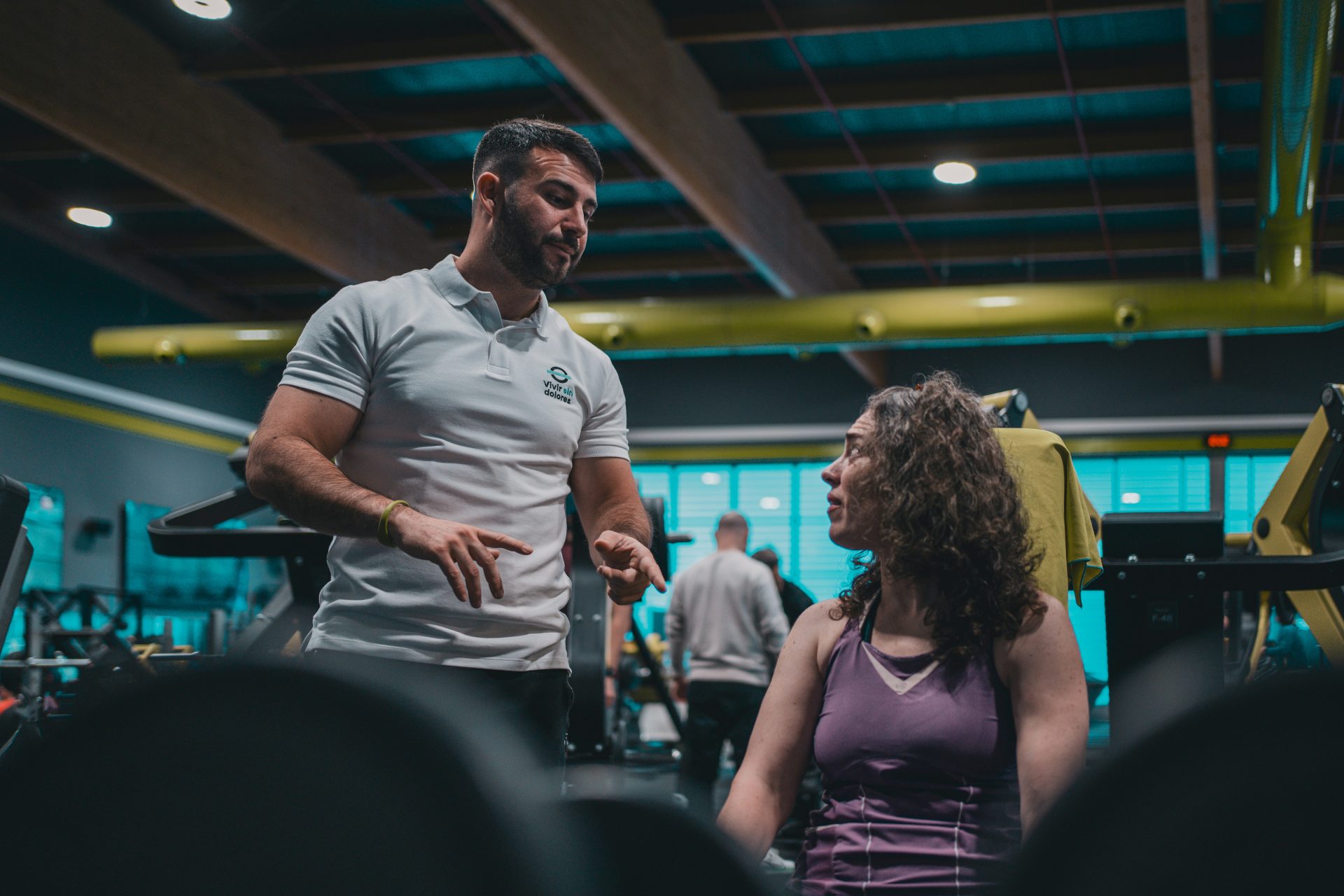 A man talking to a woman in a gym